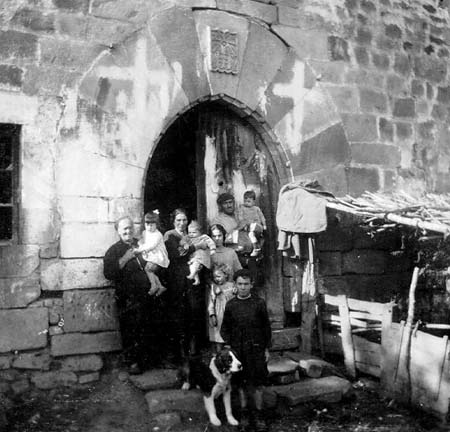 Grupo mixto de personajes en la puerta del Castillo de Ibarrola en Sara