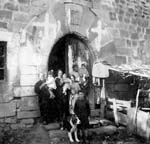 Grupo mixto de personajes en la puerta del Castillo de Ibarrola en Sara