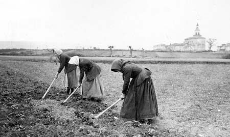 Mujeres escardando la tierra en la aldea de Ali en Vitoria-Gasteiz